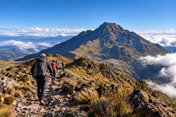 Hikers trekking through the Andean highlands on a Pasochoa Volcano acclimatization hike at 4,199 meters in Ecuador, surrounded by rugged mountain landscapes and breathtaking views.