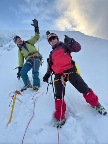 Two celebratory climbers take a selfie on the high-altitude snowy slope of Mount Chimborazo, Ecuador’s highest peak, during a guided glacier expedition.