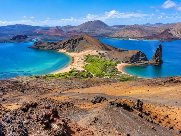 Spectacular view of Bartolomé Island in the Galapagos Islands, Ecuador, featuring volcanic craters, lava and ash fields, turquoise bays, Pinnacle Rock, and the unique geological landscapes of this iconic destination.